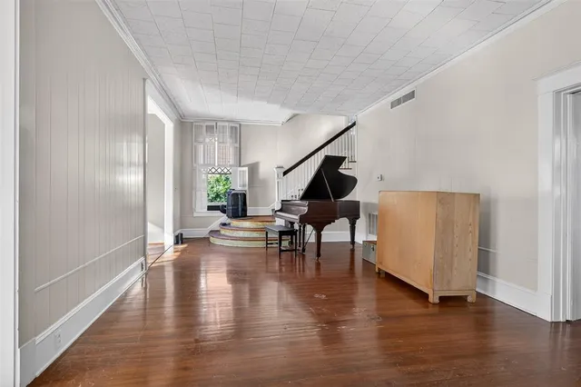 a living room with furniture and a dining table with wooden floor