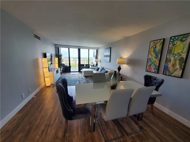 a view of a dining room with furniture a livingroom and wooden floor