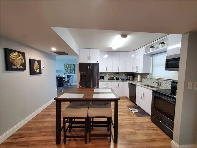 a kitchen with a table chairs refrigerator and cabinets