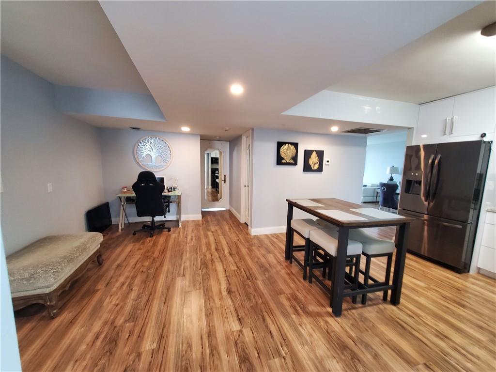 1401 North Riverside Drive, Unit 1503 Pompano Beach, FL 33062 - Photo 17 of 34 a kitchen with a table chairs refrigerator and wooden floor