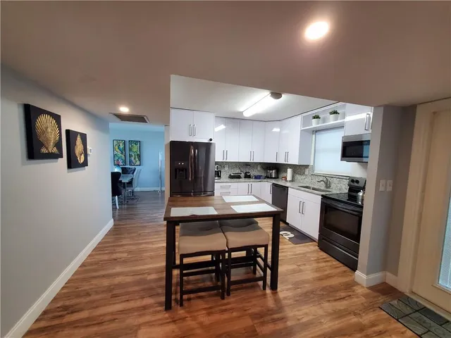 a kitchen with stainless steel appliances kitchen island granite countertop a stove a sink a refrigerator and a microwave