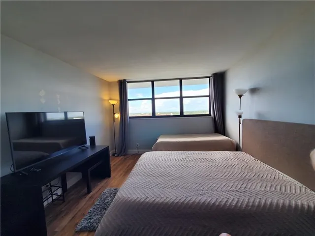 a bedroom with a large bed and a flat screen tv