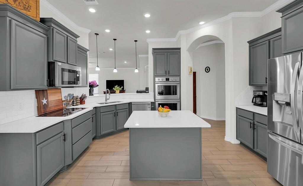 404 Calder Street Waco, TX 76712 - Photo 16 of 40 a large kitchen with stainless steel appliances kitchen island granite countertop a stove refrigerator and a sink