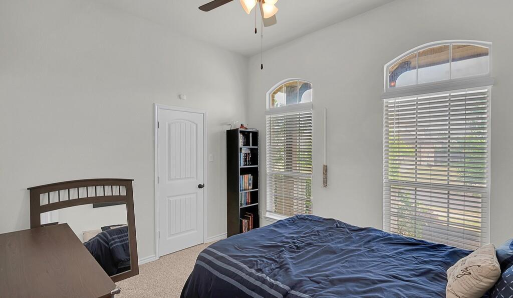 404 Calder Street Waco, TX 76712 - Photo 24 of 40 a bedroom with a large bed and a chandelier