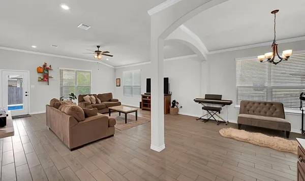 a living room with furniture and a wooden floor