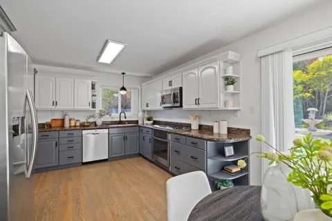 a kitchen with granite countertop a sink cabinets and window