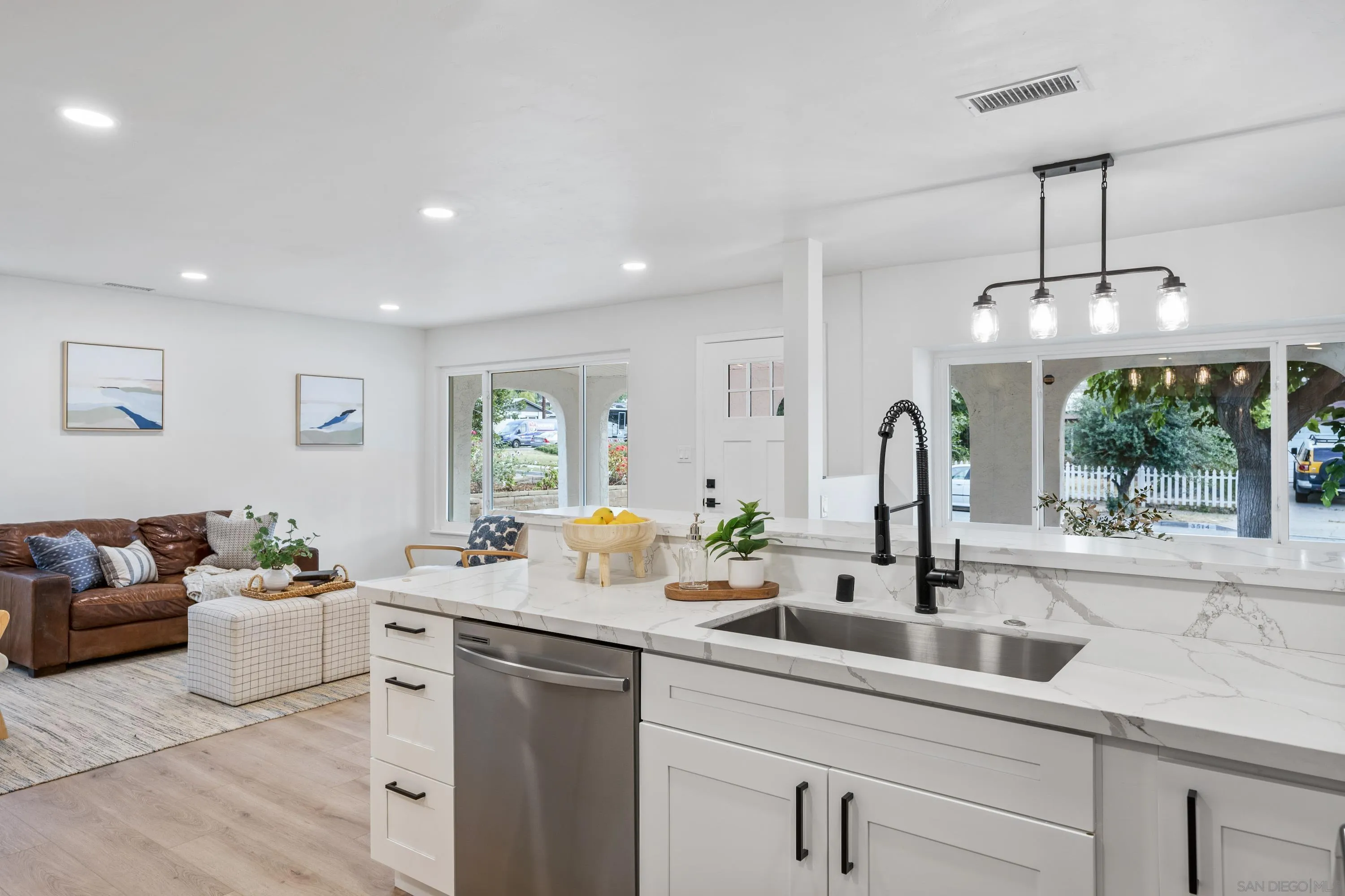 3457 Kenora Drive Spring Valley, CA 91977 - Photo 11 of 26 a open kitchen with stainless steel appliances granite countertop a sink and white cabinets with wooden floor