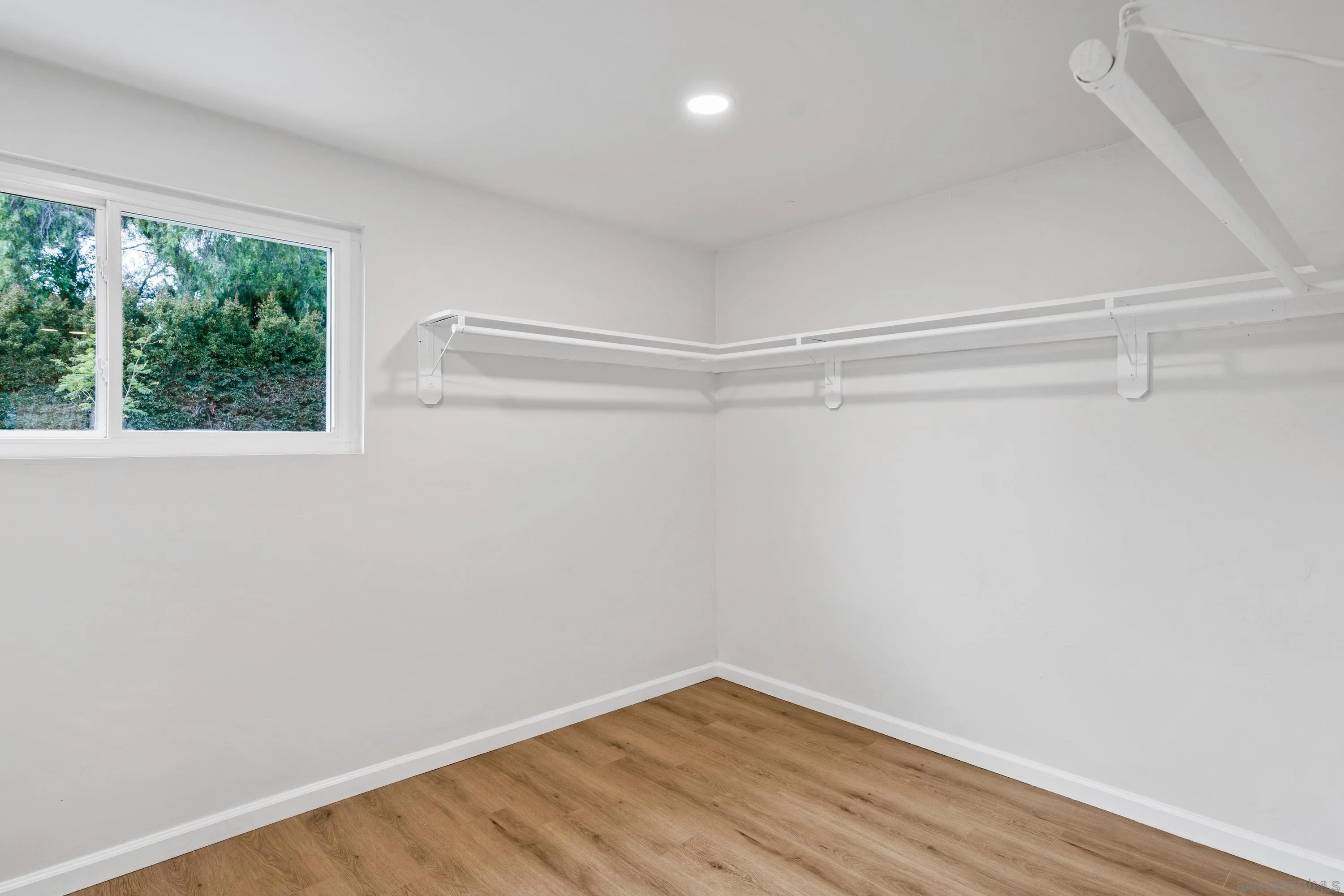 3457 Kenora Drive Spring Valley, CA 91977 - Photo 15 of 26 a view of an empty room with wooden floor and a window