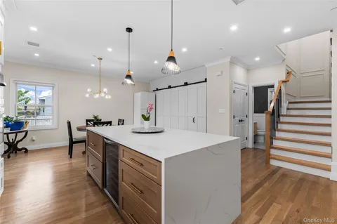 a large kitchen with kitchen island a sink a stove a dining table and chairs