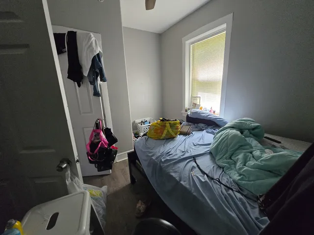 a bedroom with a bed next to a window