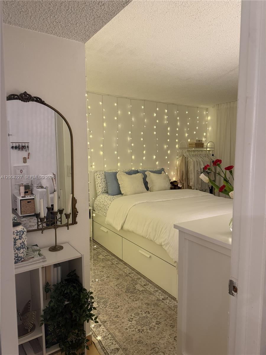 15650 Southwest 80th Street, Unit F208 Miami, FL 33193 - Photo 12 of 19 a spacious bedroom with a bed a table and chairs