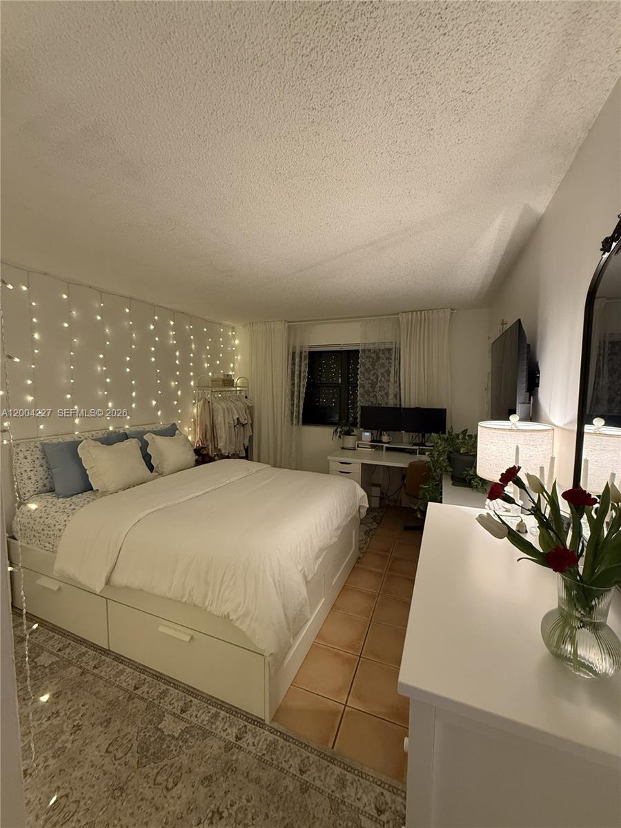 15650 Southwest 80th Street, Unit F208 Miami, FL 33193 - Photo 13 of 19 a bed room with a bed window and mirror