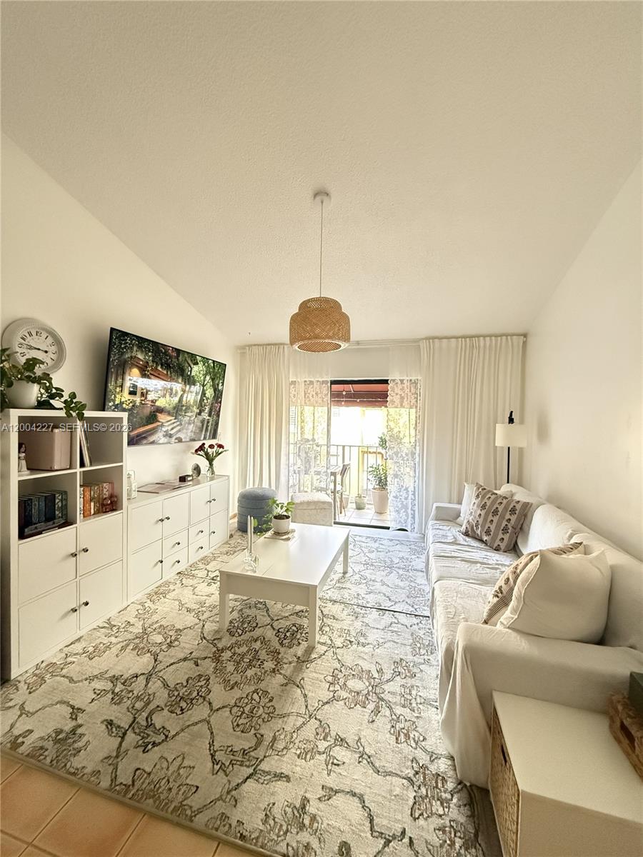 15650 Southwest 80th Street, Unit F208 Miami, FL 33193 - Photo 5 of 19 a living room with furniture and a flat screen tv