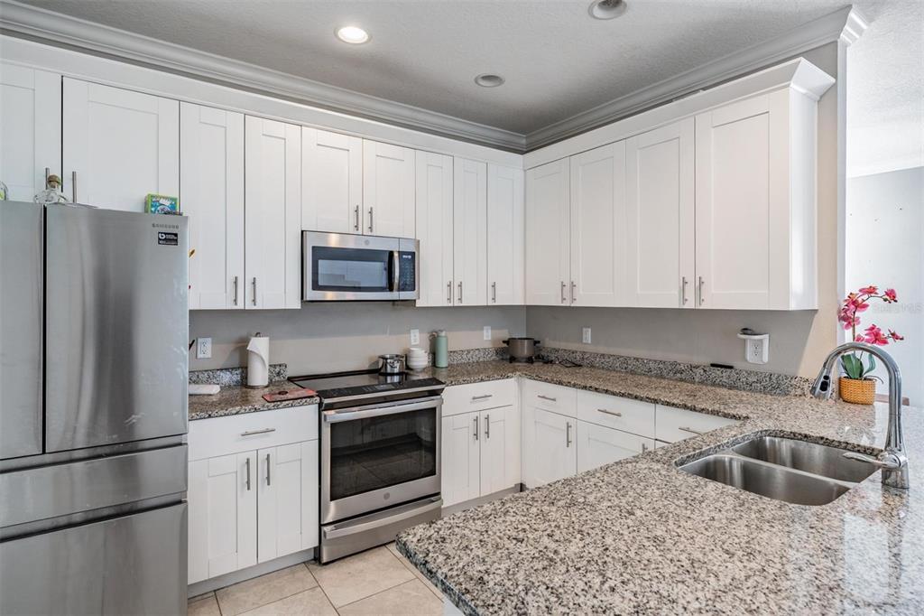 3016 Alachua Place New Port Richey, FL 34655 - Photo 3 of 65 a kitchen with granite countertop a sink stove and refrigerator