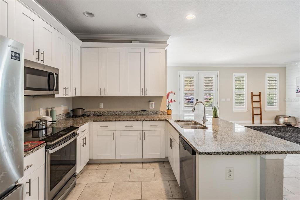 3016 Alachua Place New Port Richey, FL 34655 - Photo 6 of 65 a kitchen with granite countertop stainless steel appliances a sink a stove top oven and cabinets