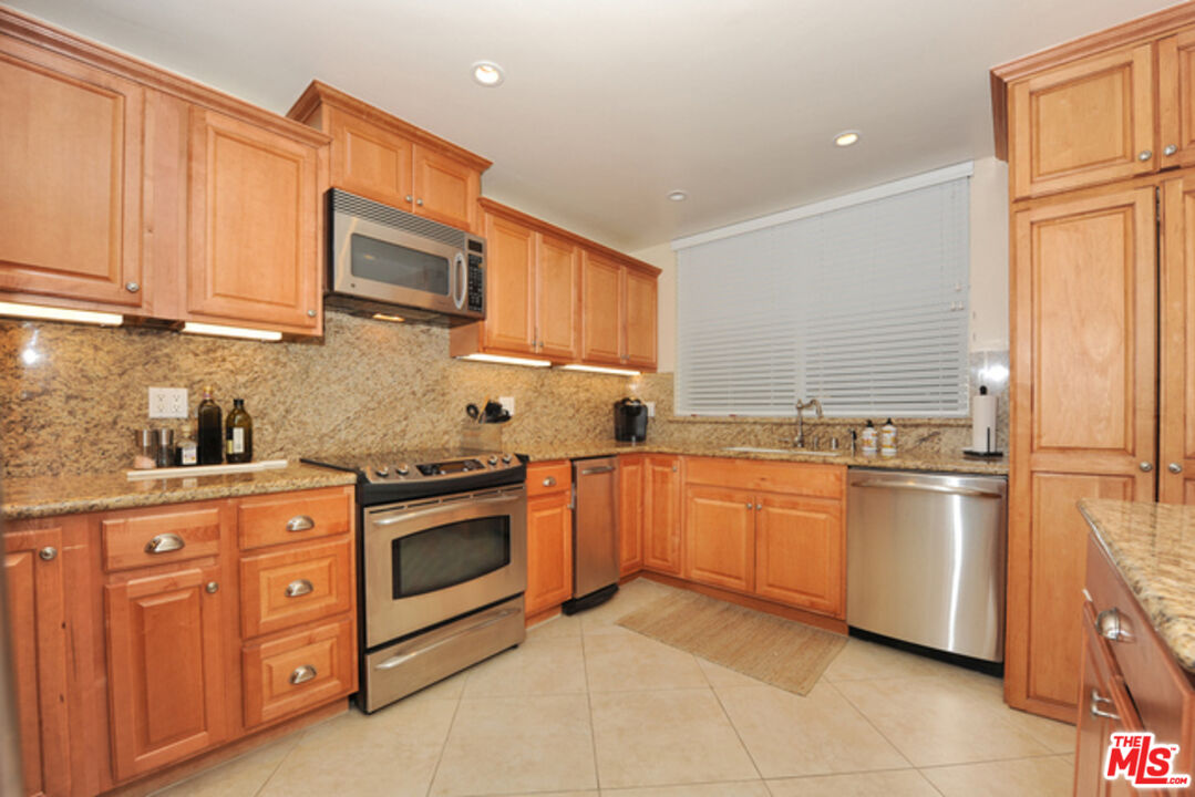 4 Lighthouse Street, Unit 5 Marina del Rey, CA 90292 - Photo 10 of 25 a kitchen with stainless steel appliances granite countertop a refrigerator a stove top oven a sink and dishwasher