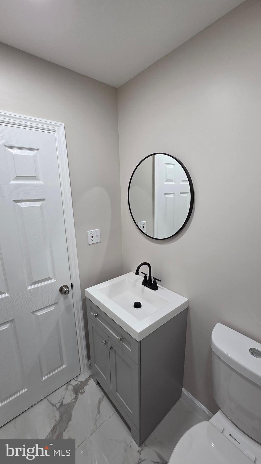 5706 Vandike Street Philadelphia, PA 19135 - Photo 18 of 32 a bathroom with a sink mirror and toilet