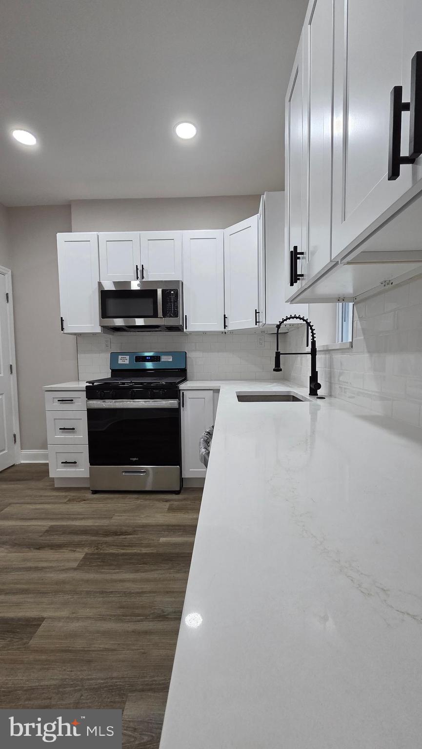 5706 Vandike Street Philadelphia, PA 19135 - Photo 10 of 32 a kitchen with stainless steel appliances a stove a sink and a refrigerator