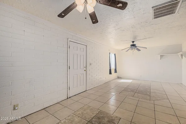 an empty room with fan and windows