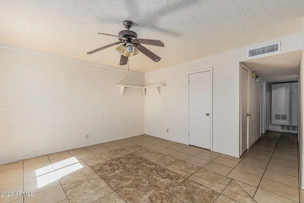 a view of a room with a chandelier fan and closet area
