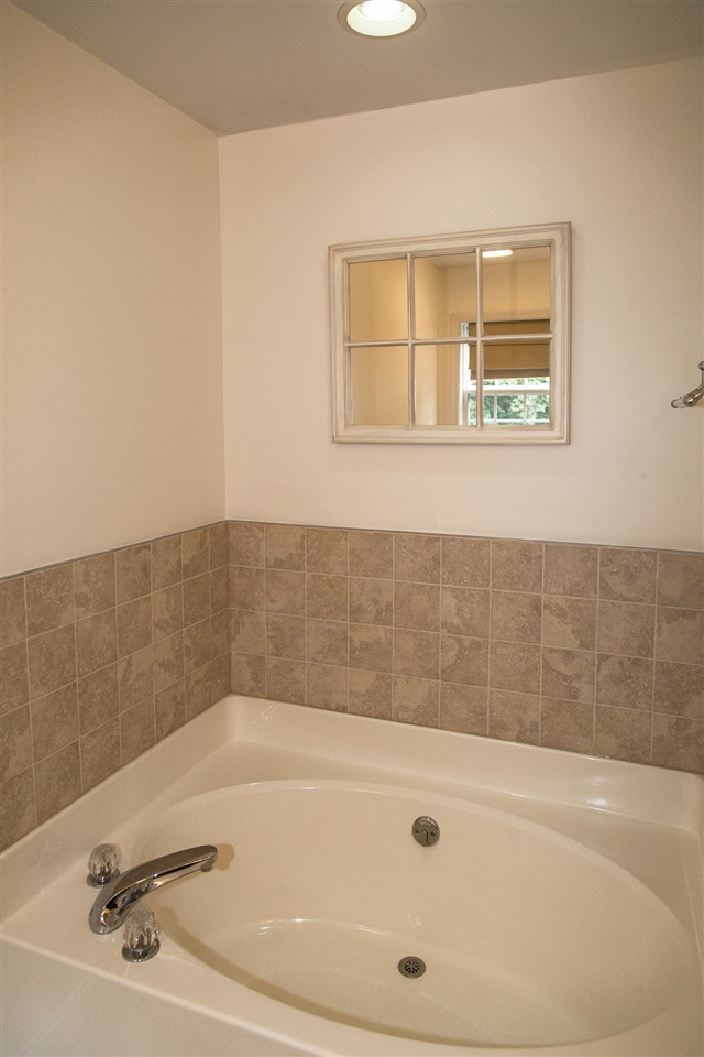 72 Willow Way Road Barboursville, VA 22923 - Photo 33 of 50 The soaking tub has a soft gray tile surrounding it. The mirror above the tile allows one to relax and look outside in complete privacy.