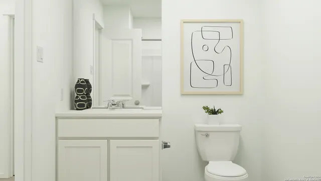 a bathroom with a toilet sink and mirror