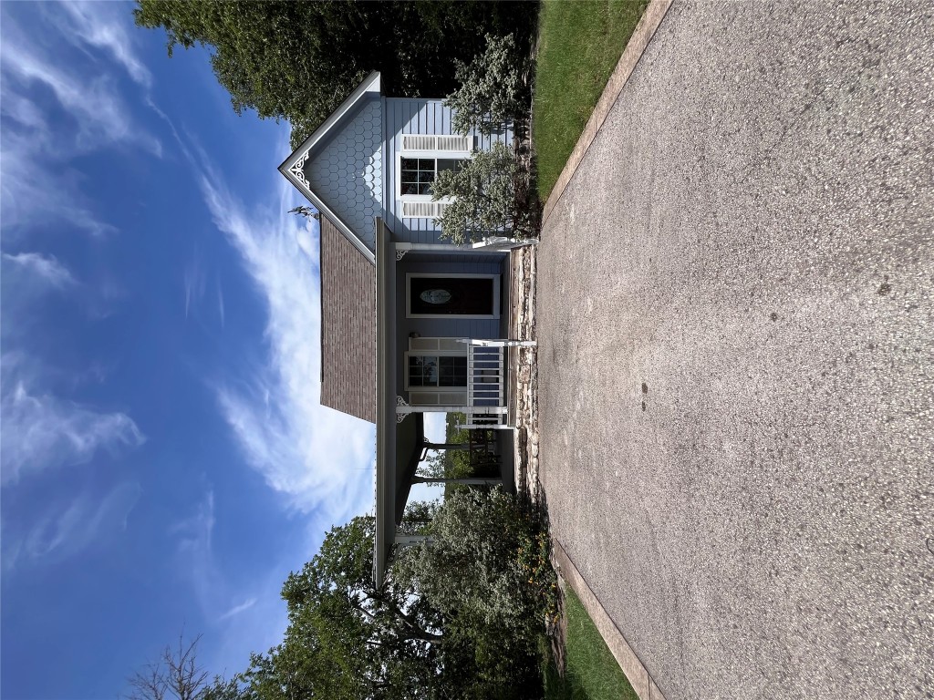 a view of a house with a yard and potted plants