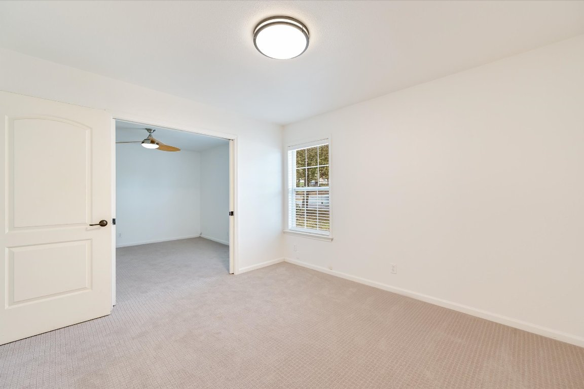 8806 El Rey Boulevard Austin, TX 78737 - Photo 18 of 35 Spare room with carpet flooring, ceiling fan and a window for natural light