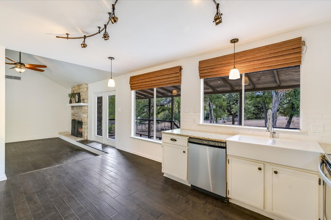 8806 El Rey Boulevard Austin, TX 78737 - Photo 5 of 35 Kitchen with stainless steel appliances, hanging light fixtures, dark wood finished floors, rail lighting, and lofted ceiling