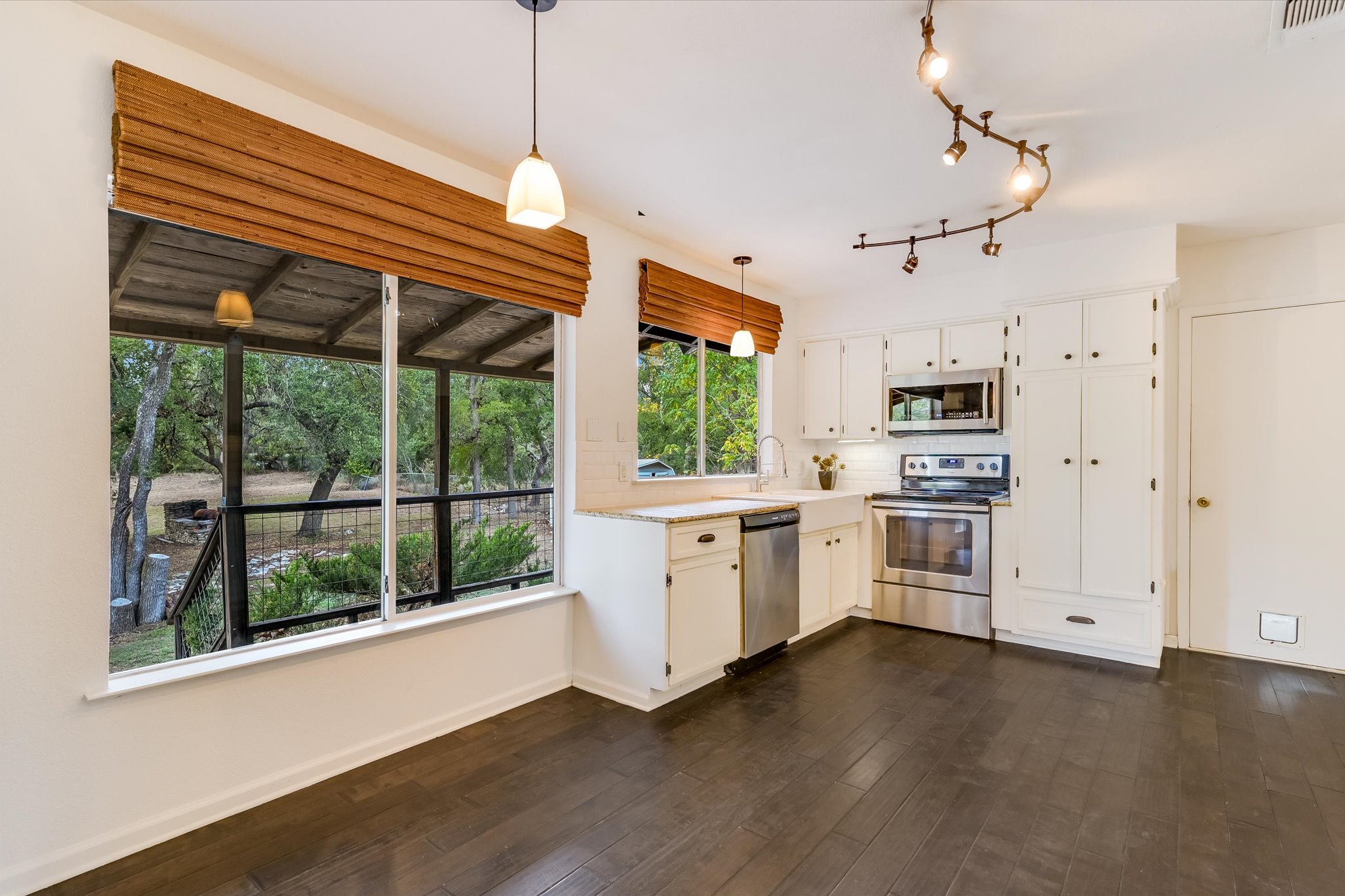 8806 El Rey Boulevard Austin, TX 78737 - Photo 7 of 38 a kitchen with white cabinets and wooden floors