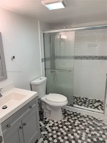 a bathroom with a sink a toilet a shower and a mirror