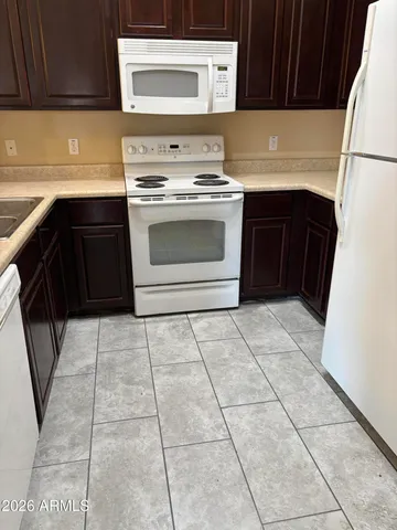 a kitchen with a stove top oven cabinets and a refrigerator
