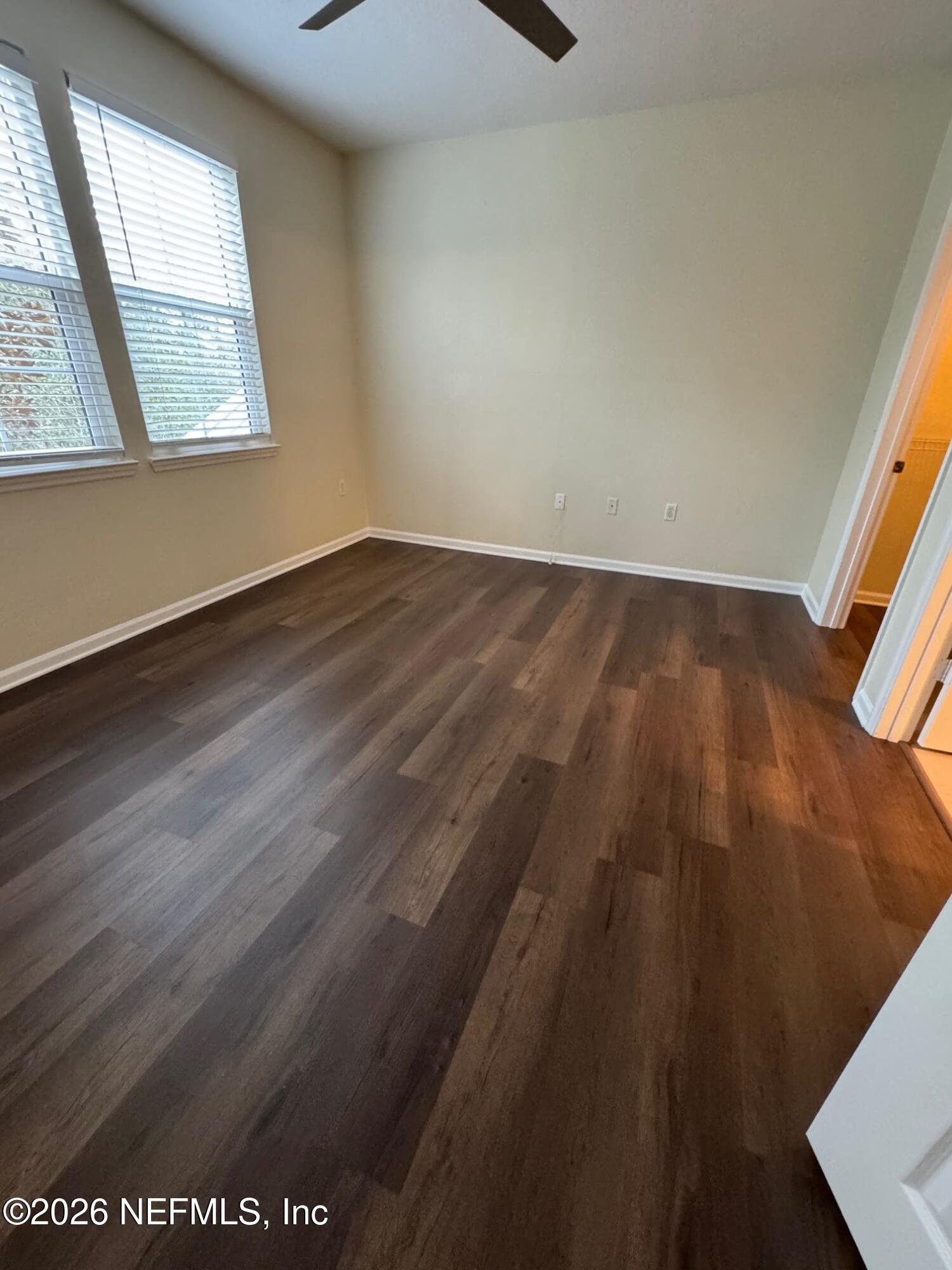 8550 Touchton Road, Unit 1727 Jacksonville, FL 32216 - Photo 6 of 15 an empty room with wooden floor and windows