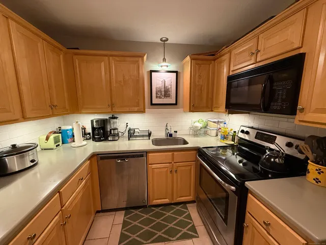 a kitchen with stainless steel appliances a stove a sink a microwave and cabinets