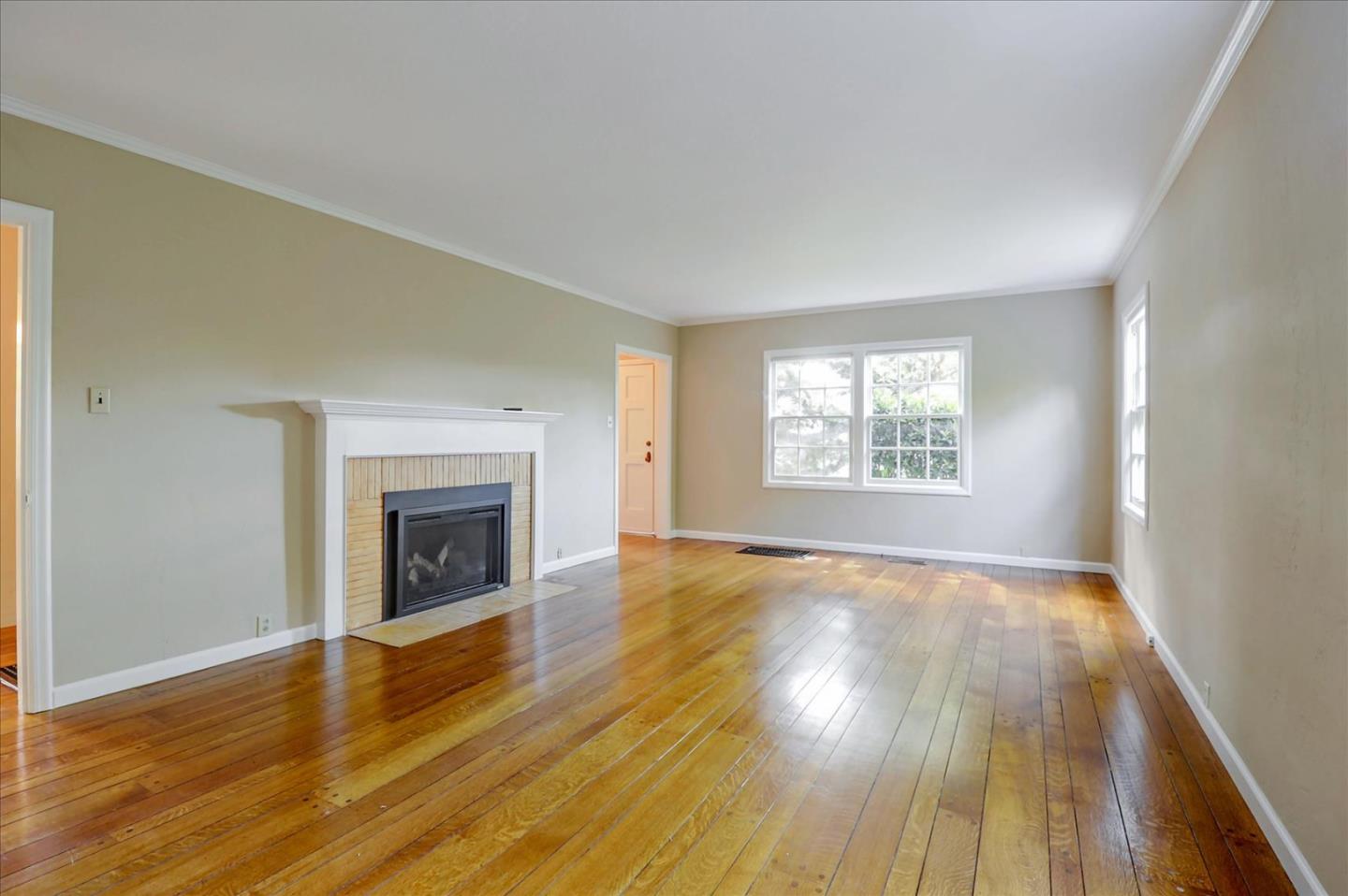 420 Sunset Boulevard Hayward, CA 94541 - Photo 6 of 51 an empty room with wooden floor fireplace and windows