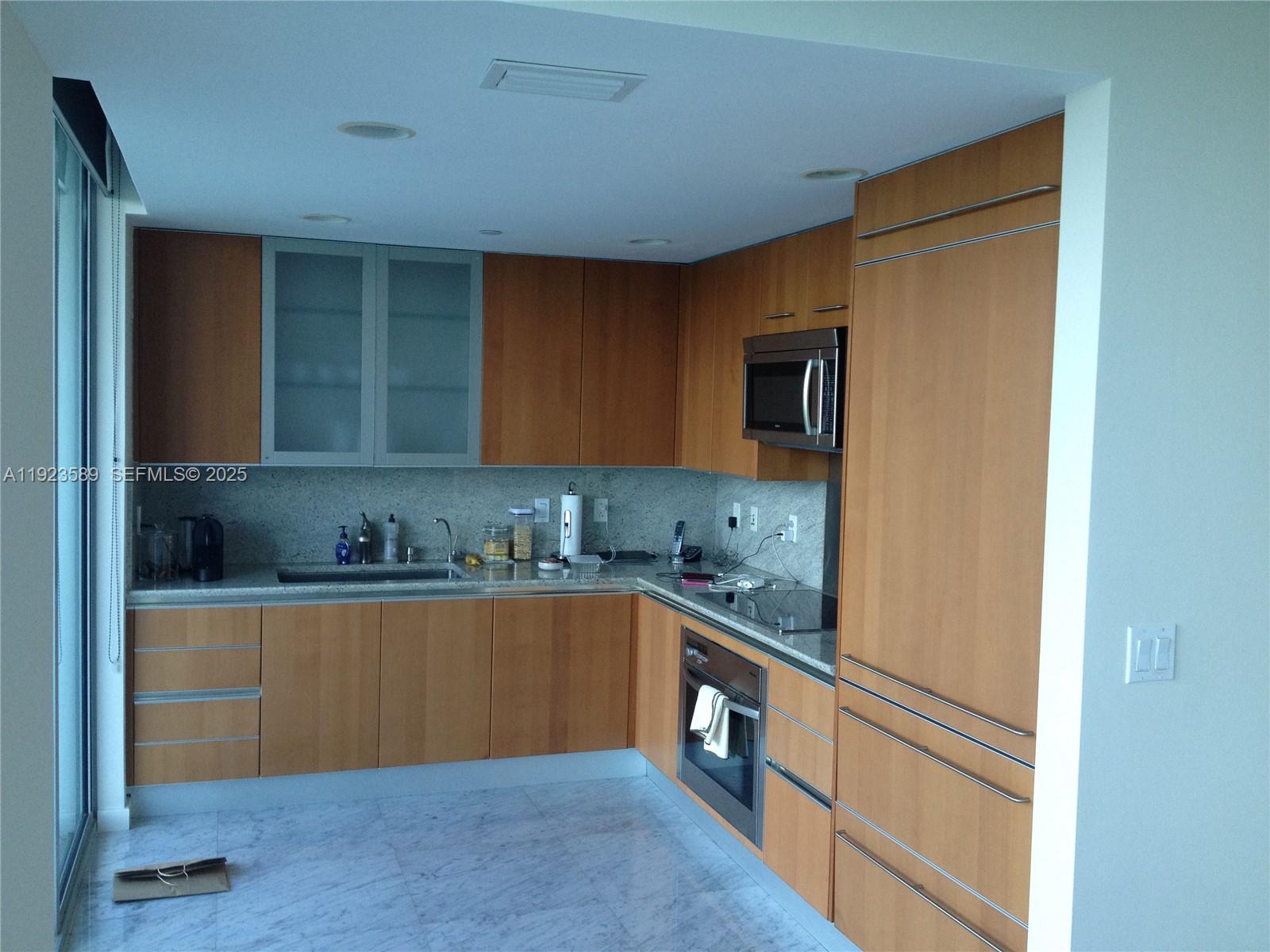a kitchen with granite countertop cabinets stainless steel appliances and a sink