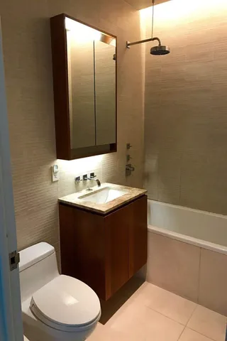 a bathroom with a sink vanity mirror and toilet