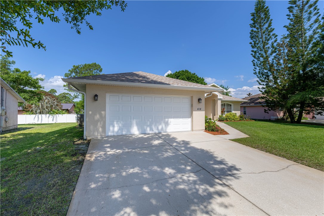 414 Ash Street Sebastian, FL 32958 - Photo 4 of 36 a front view of a house with a yard and garage