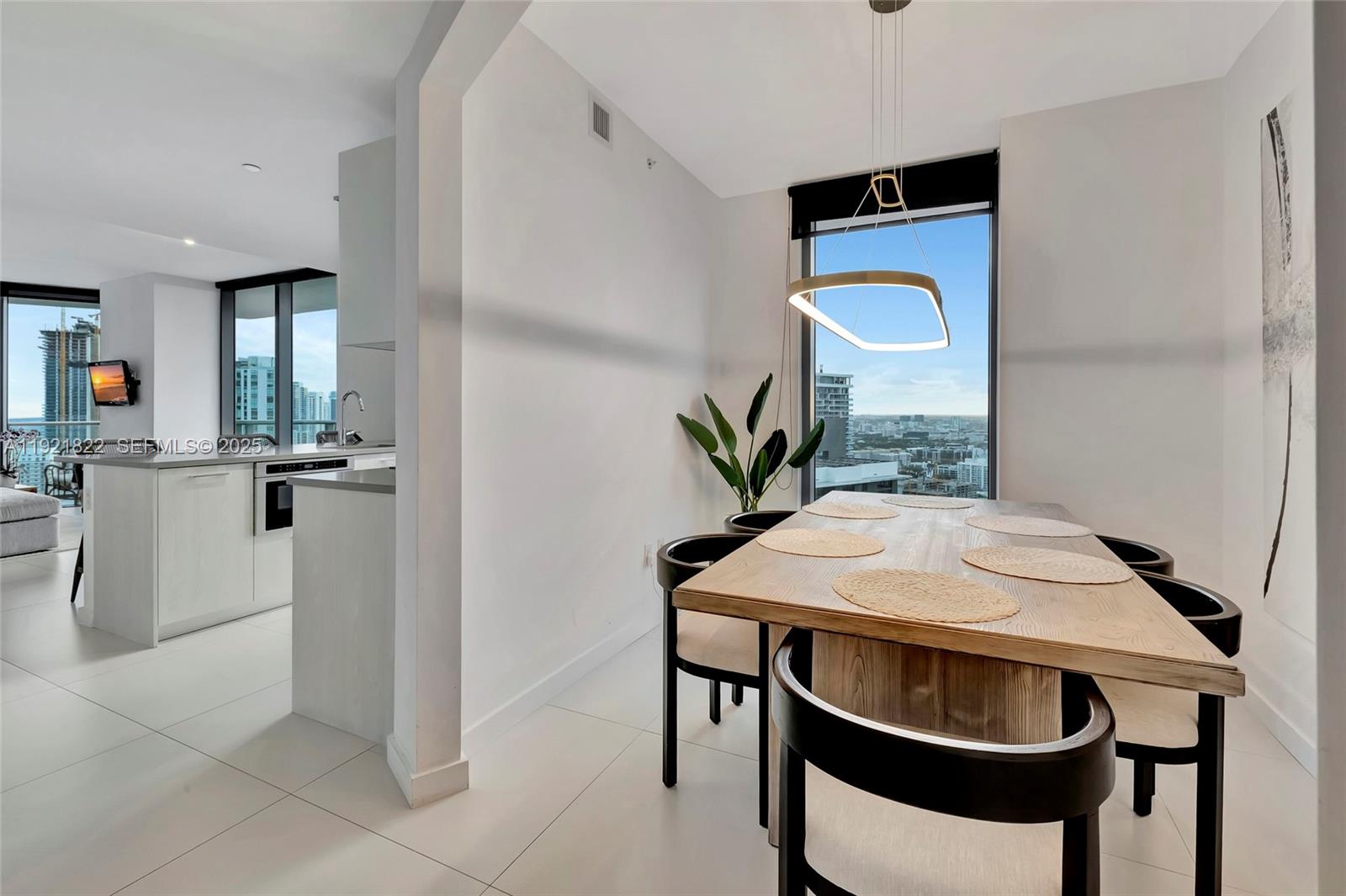501 Northeast 31st Street, Unit 3708 Miami, FL 33137 - Photo 11 of 31 a kitchen with stainless steel appliances a table and chairs in it