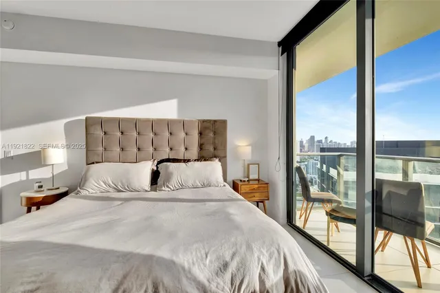 a large bedroom with a large bed and a balcony view