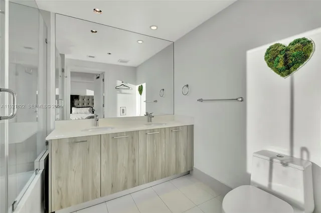 a spacious bathroom with a toilet a sink and mirror