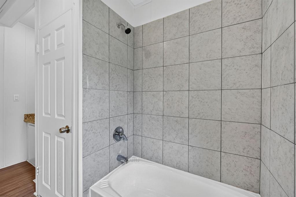 13405 Wheat Road Venus, TX 76084 - Photo 23 of 32 Bathtub and shower combination featuring light-toned tile surround, chrome fixtures, and a rain showerhead