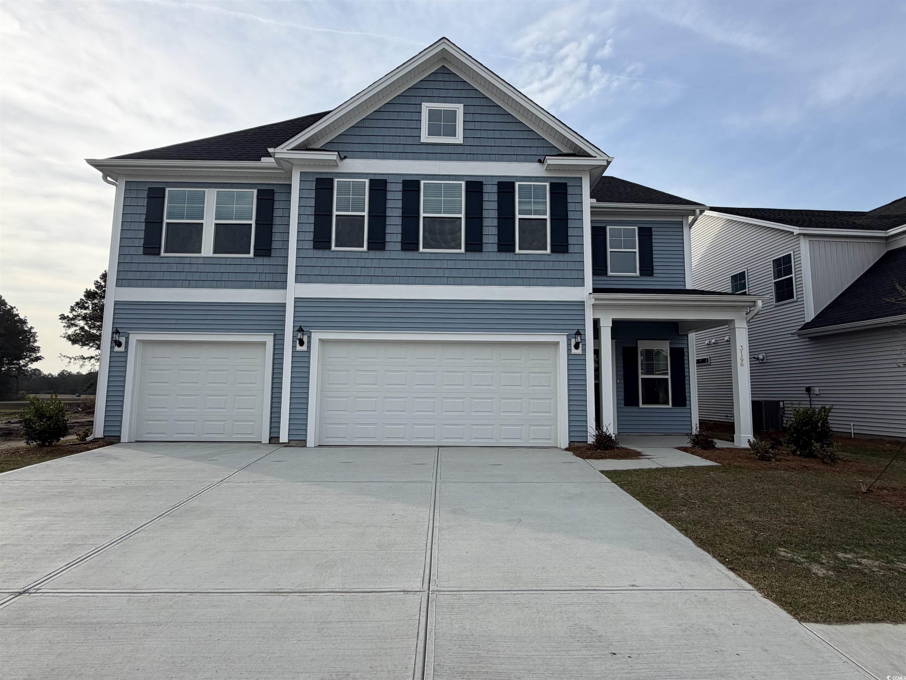 View of front of property featuring a shingled roof, a front yard, driveway, and an attached garage