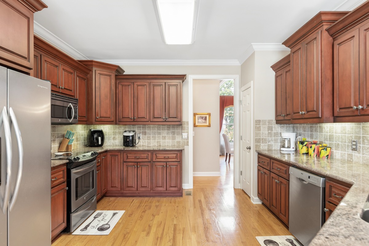 105 Robin Point Gallatin, TN 37066 - Photo 22 of 59 a kitchen with stainless steel appliances granite countertop a refrigerator a sink dishwasher a stove with wooden cabinets and floor