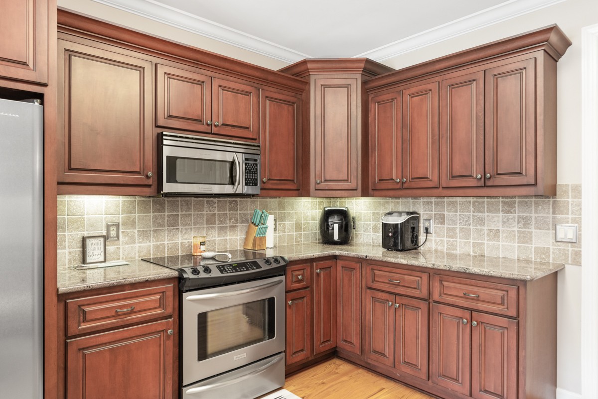 105 Robin Point Gallatin, TN 37066 - Photo 23 of 59 a kitchen with stainless steel appliances granite countertop a sink dishwasher stove and microwave with wooden cabinets