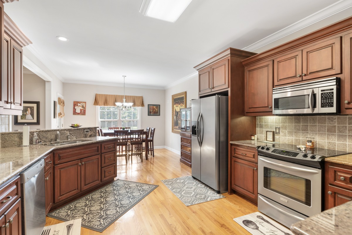 105 Robin Point Gallatin, TN 37066 - Photo 25 of 59 a kitchen with stainless steel appliances granite countertop a stove top oven a sink dishwasher a refrigerator and cabinets with wooden floor