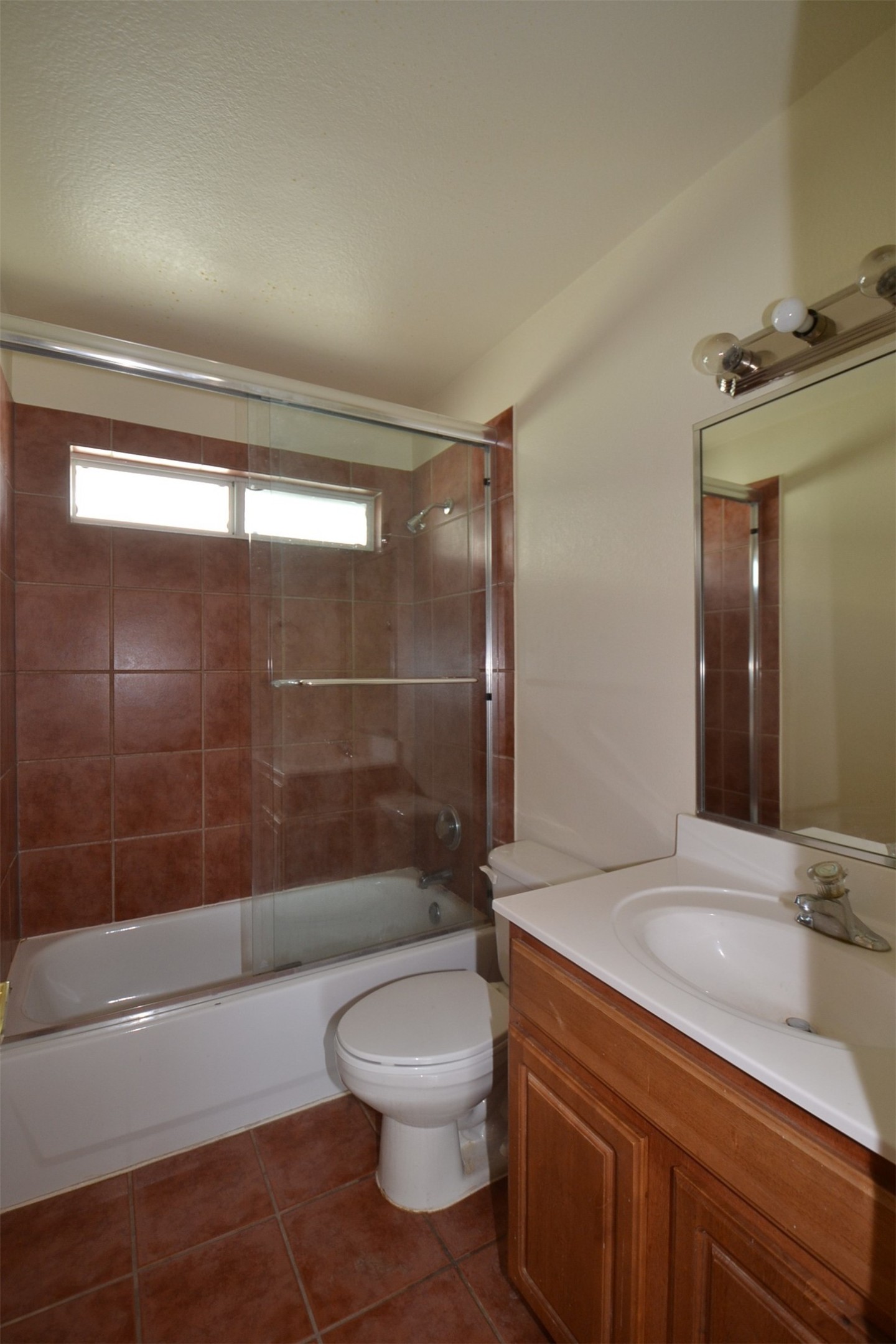 6912 Meador Avenue, Unit A Austin, TX 78752 - Photo 13 of 22 Bathroom with vanity, dark tile patterned floors, and shower / bath combination with glass door
