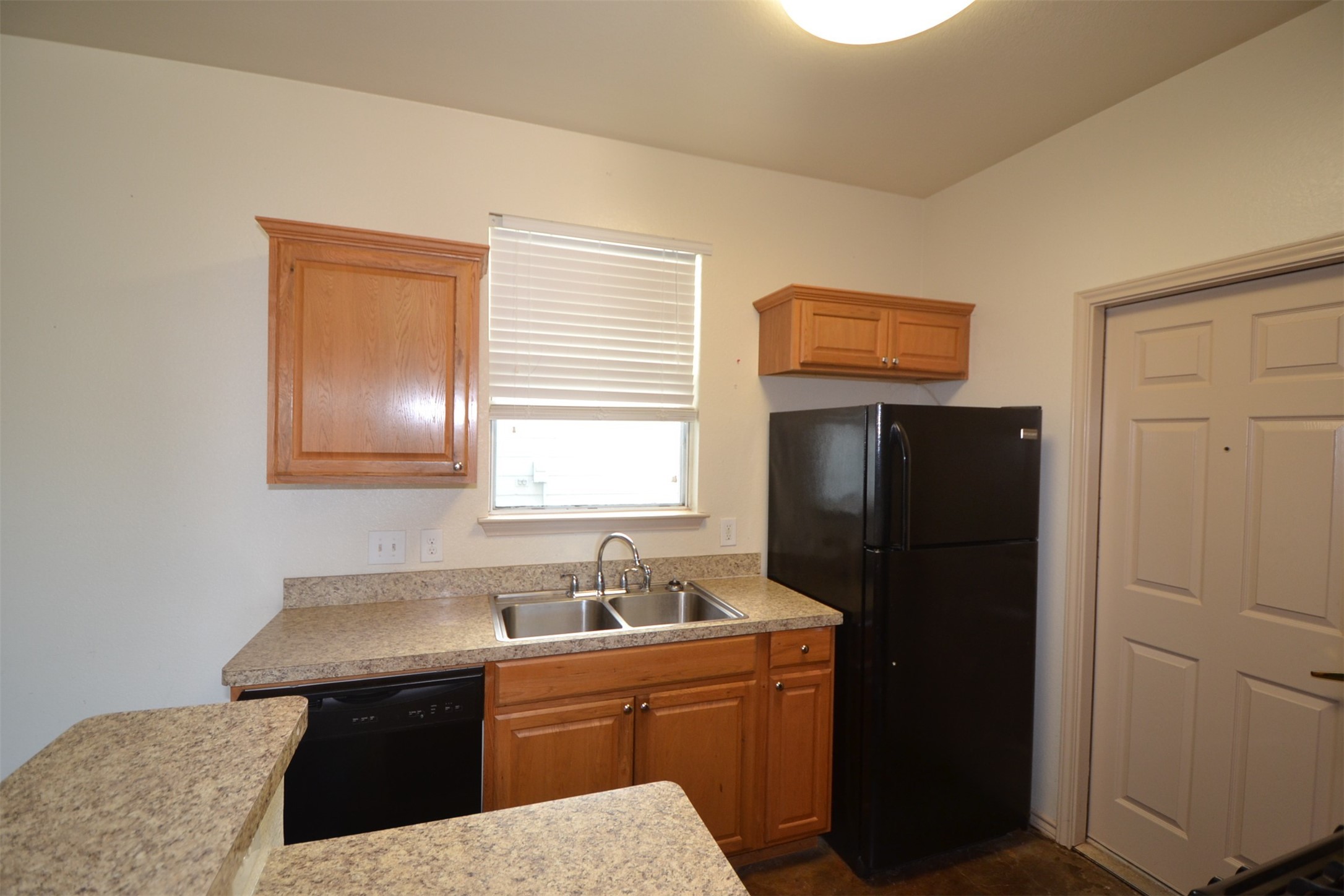 6912 Meador Avenue, Unit A Austin, TX 78752 - Photo 4 of 22 Kitchen featuring light countertops, black appliances, and wood finish cabinetry