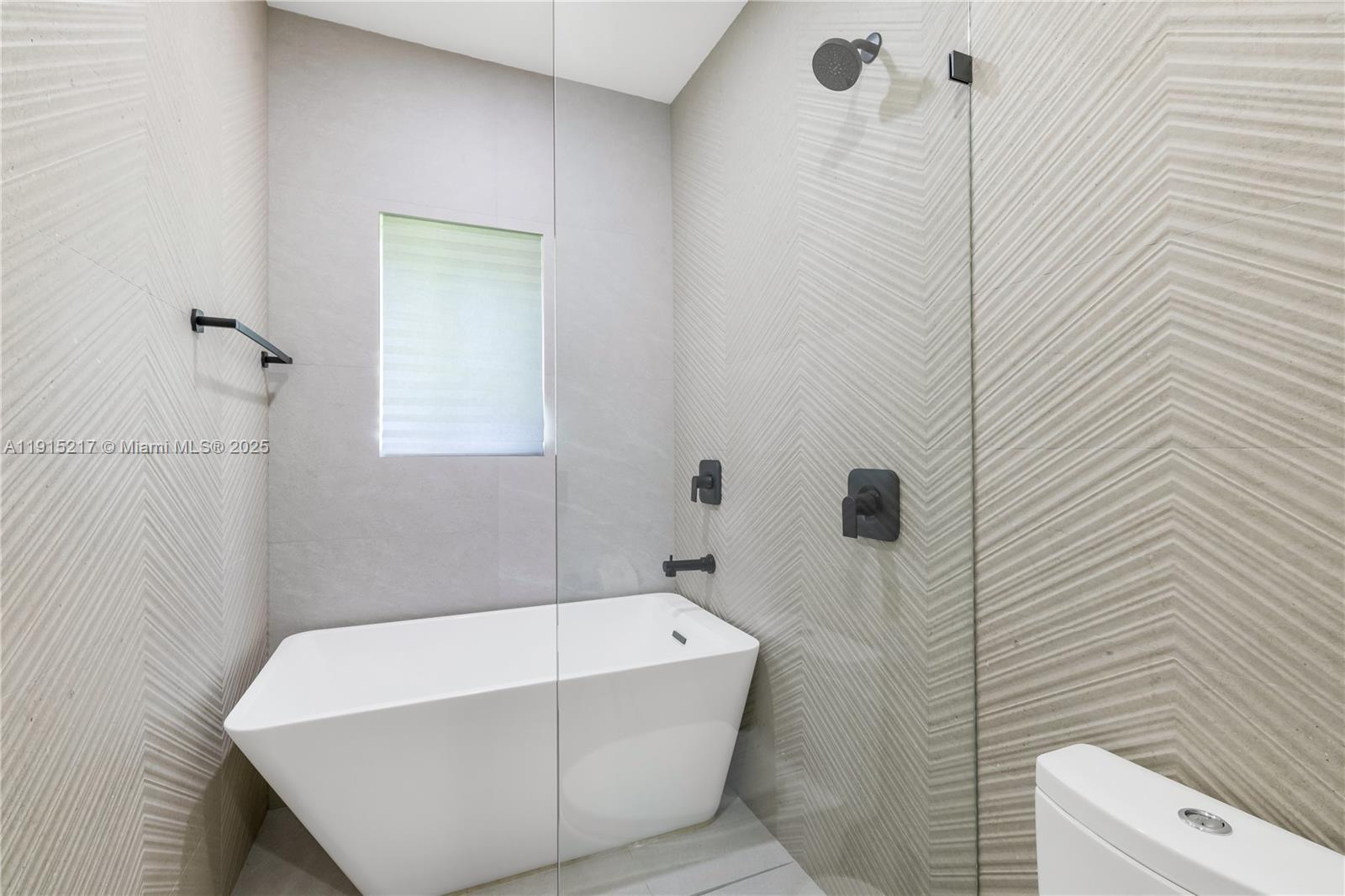 8941 Southwest 65th Court, Unit 8941 Pinecrest, FL 33156 - Photo 36 of 85 a bathroom with a white bath tub and a shower