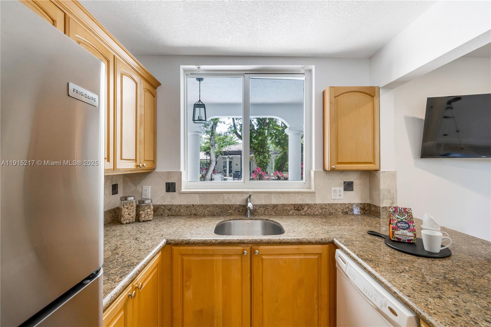 8941 Southwest 65th Court, Unit 8941 Pinecrest, FL 33156 - Photo 44 of 85 a kitchen with granite countertop a sink a window and counter top space